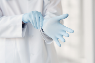 Surgeon putting on gloves