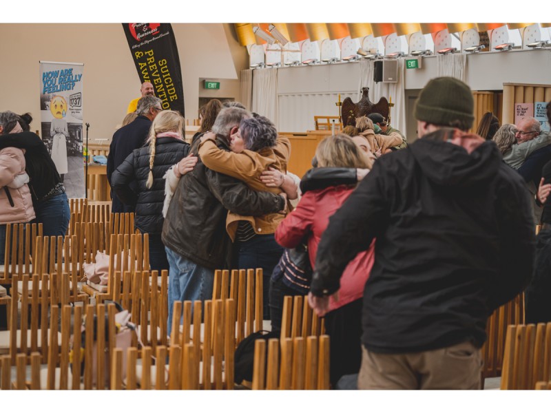 Attendees of The Broken Movement Trust event share a hug during the event